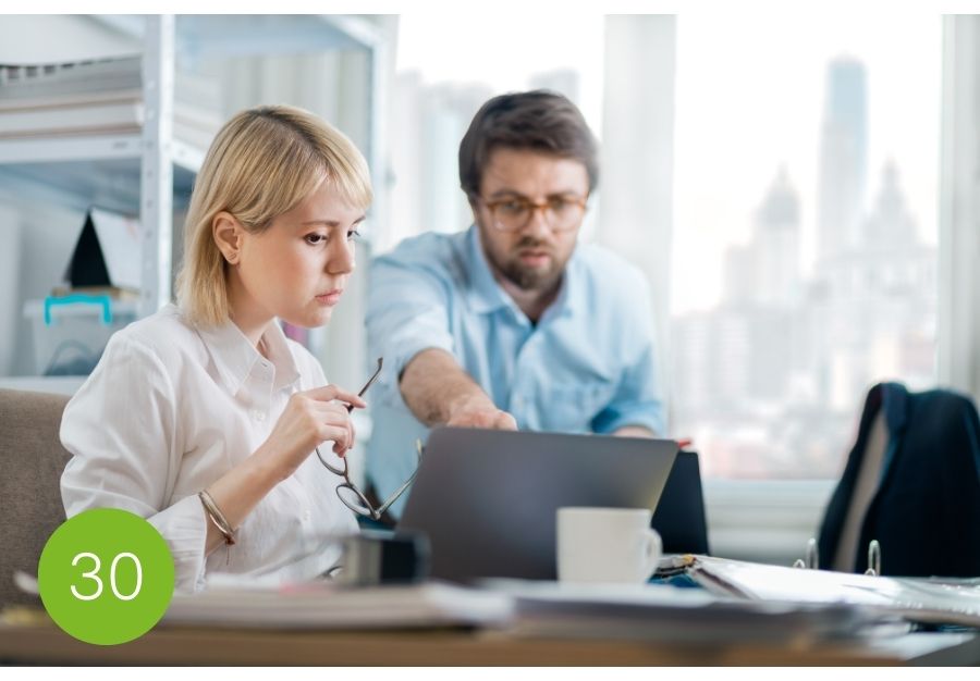 Zwei Menschen im Büro reden miteinander. Konstruktives Feedback geben, statt diskutieren.