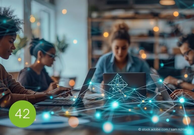 Künstliche Intelligenz im Teamkontext Mehrere Personen arbeiten konzentriert am Laptop, digitale Vernetzungen symbolisieren die Integration von KI in die Teamarbeit