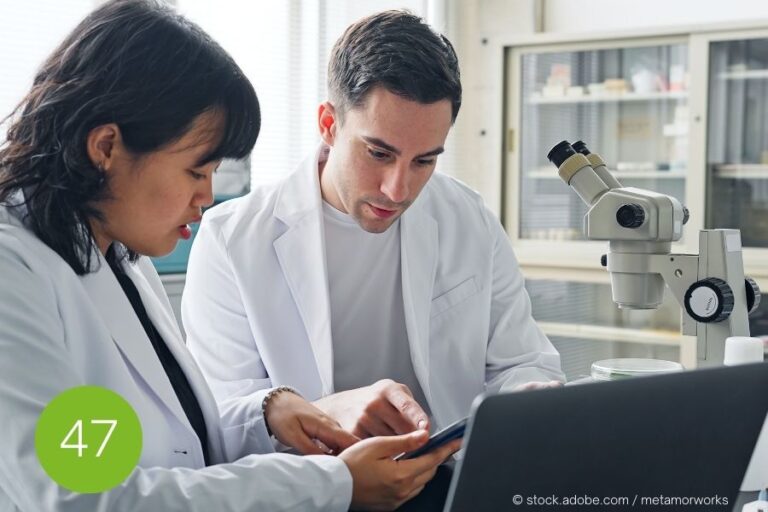 Klärung wissenschaftlicher Erwartungen im Gespräch Zwei Forschende in Laborkitteln besprechen konzentriert Informationen auf einem Tablet – Symbol für präzise Kommunikation im akademischen Kontext