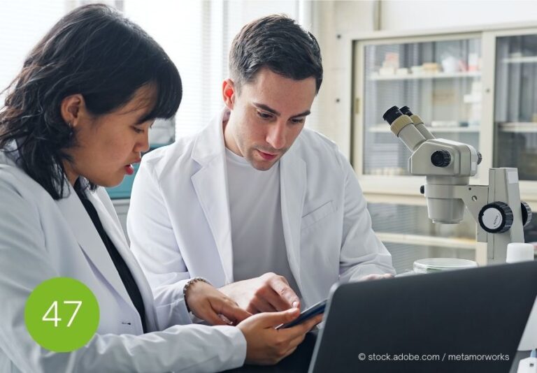 Klärung wissenschaftlicher Erwartungen im Gespräch Zwei Forschende in Laborkitteln besprechen konzentriert Informationen auf einem Tablet – Symbol für präzise Kommunikation im akademischen Kontext